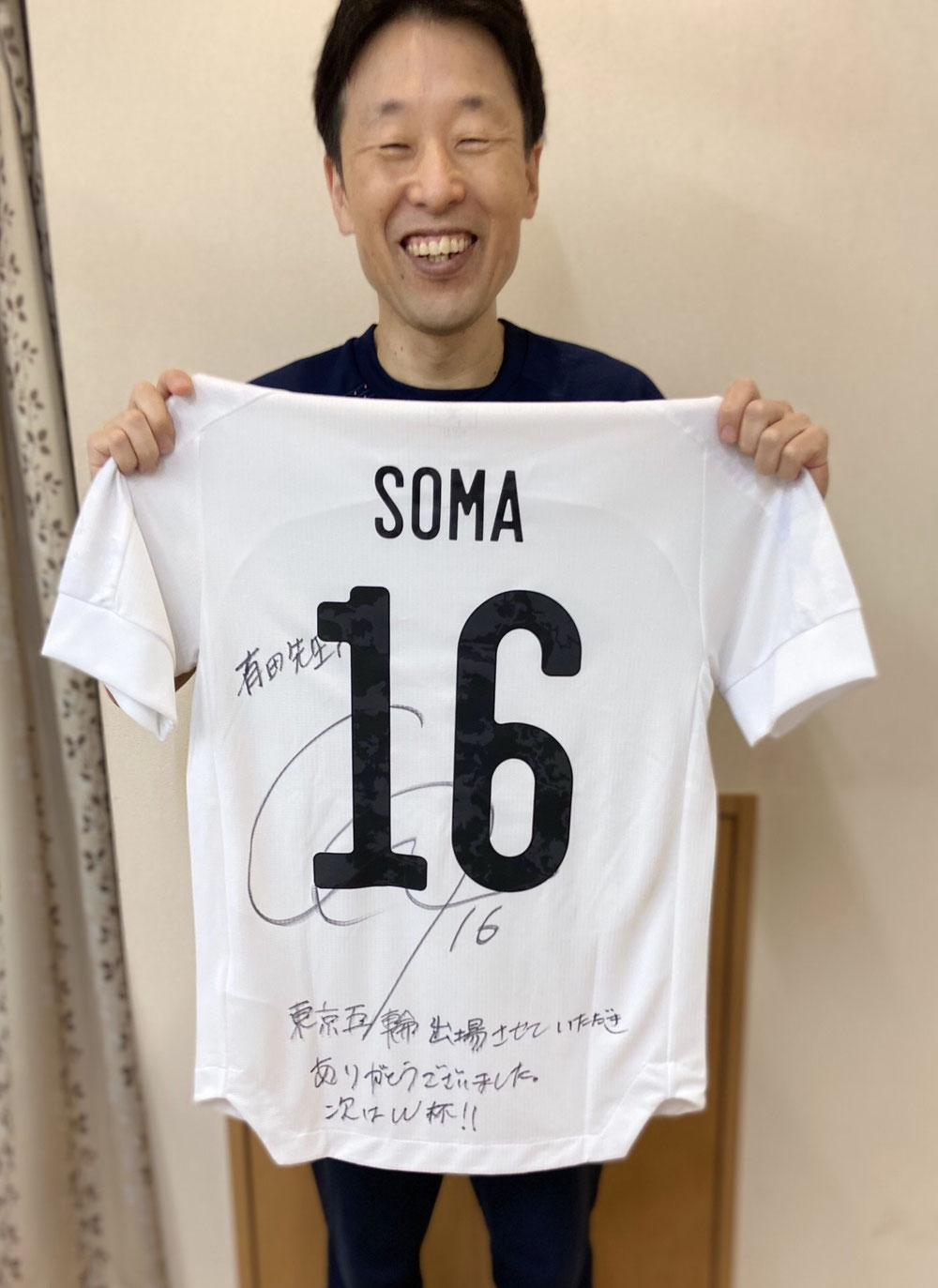 相馬勇紀選手のサイン入りユニフォームを持つ院長